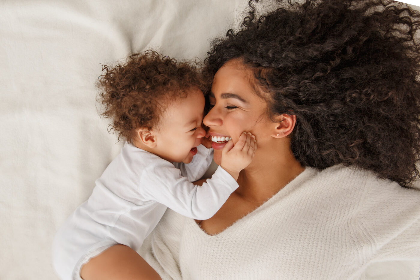Mother and toddler laughing together, nose to nose